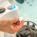 man holding chlorine tablet on a hot tub