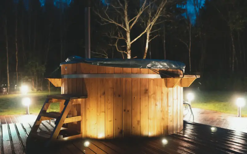 wooden hot tub with cover at night
