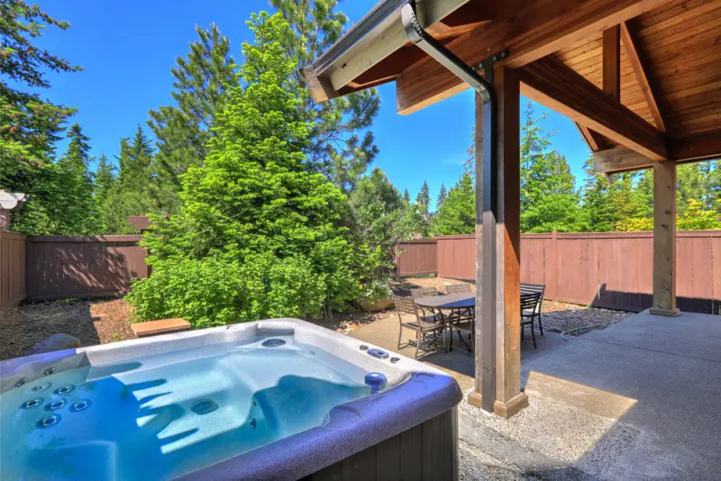 fenced backyard with hot tub