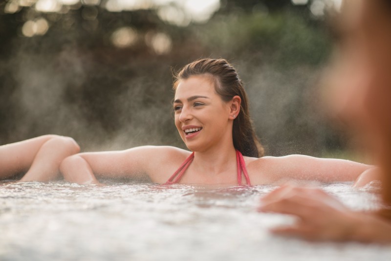woman smiling while bathing in a hot tub