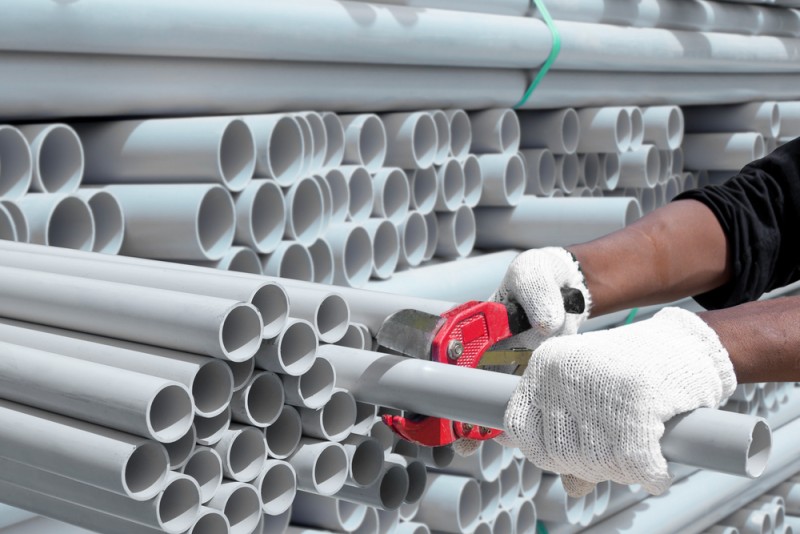worker cutting pvc pipes