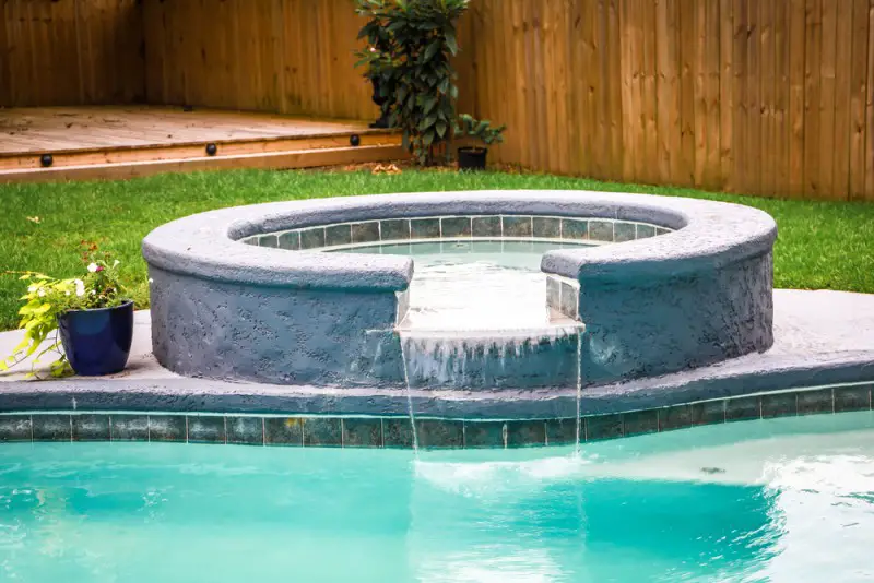 hot tub next to a swimming pool